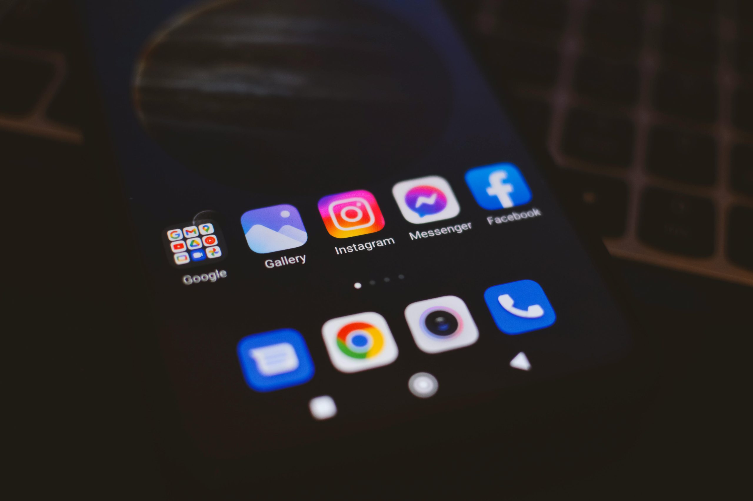 A smartphone displaying popular social media apps in a dimly lit environment, perfect for tech and communication themes.